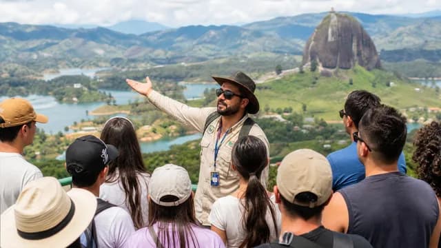 Guia turístico certificado explicando a paisagem a um grupo no mirante de Guatapé